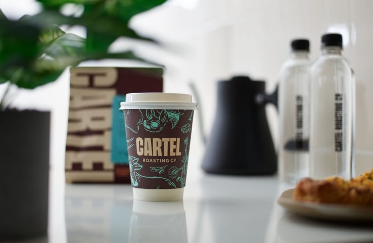 A take-out coffee on a counter at Cartel Coffee at the Camby