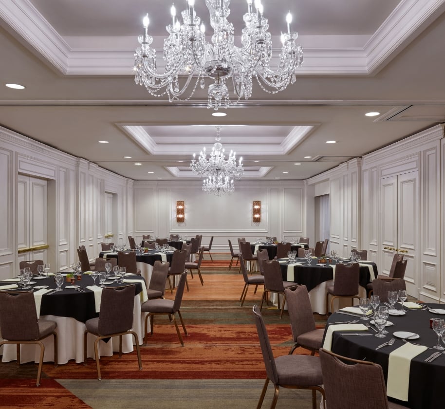 An indoor meeting space at the Camby with 6 large round tables setup for an event