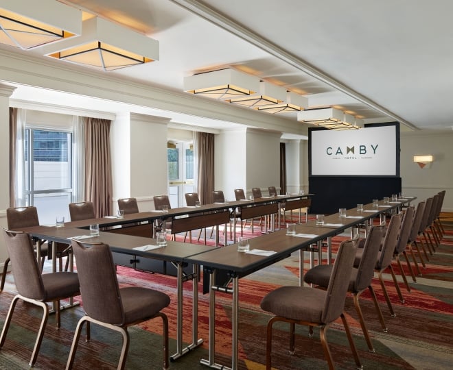 A large indoor meeting room at the Camby with tables connected in a 