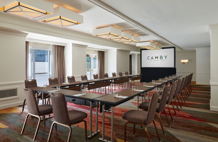 A large indoor meeting room at the Camby with tables connected in a 