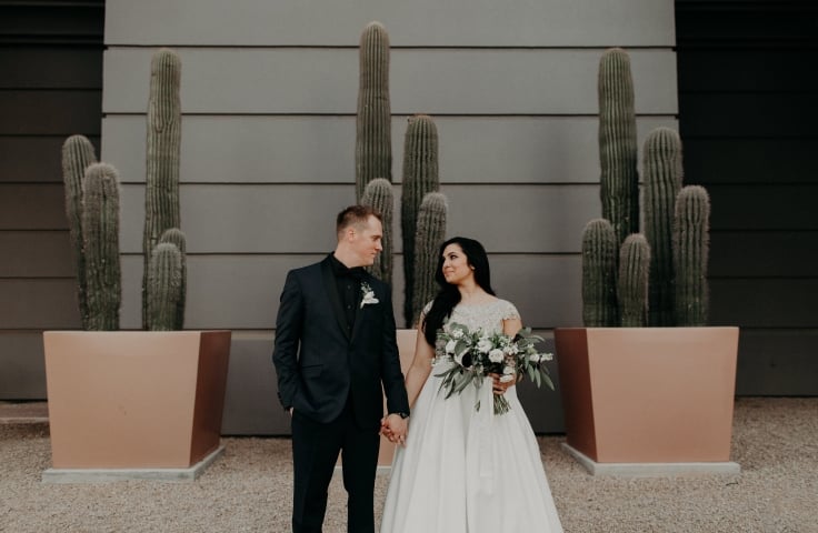 A bride and. groom holding hands at the Camby