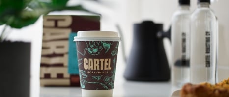 A to go coffee on the counter at Cartel Coffee