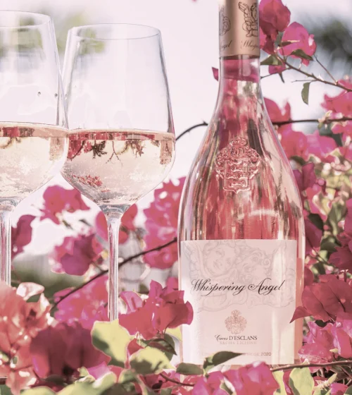 Whispering Angel, Château d’Esclans, rose wine bottle, 2 wine glasses, pink Bougainvillea flowers in background