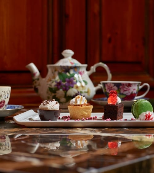 Tea pot and tea cups with dessert tray