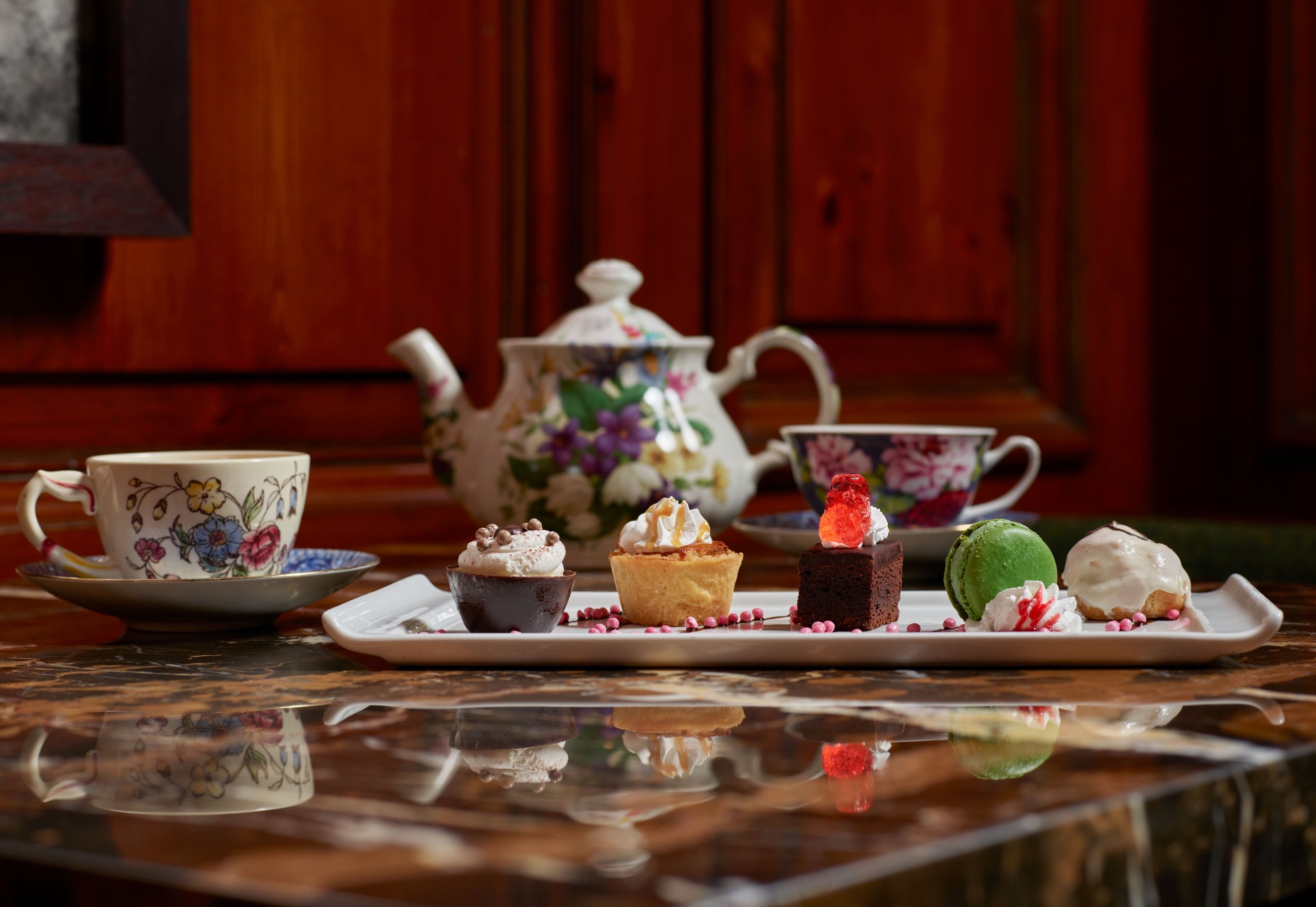 Tea pot and tea cups with dessert tray