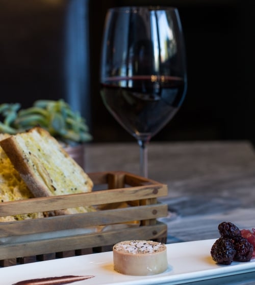 red wine in glass with bread and cheese plate
