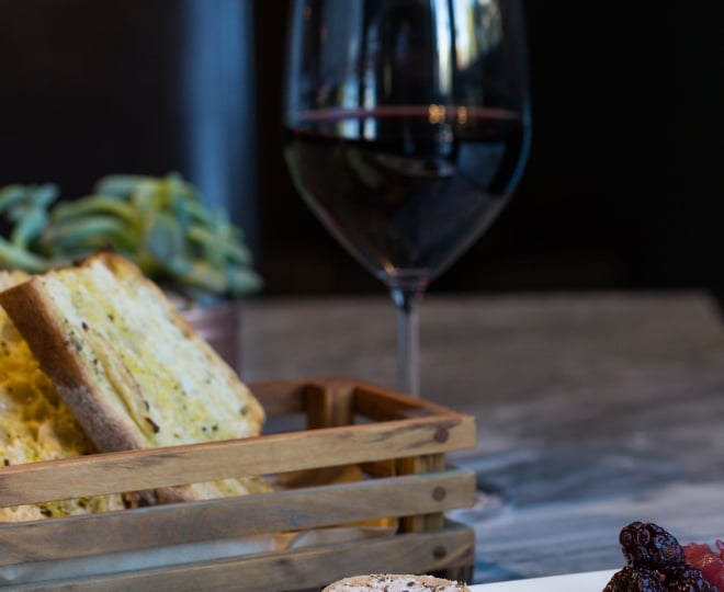 red wine in glass with bread and cheese plate