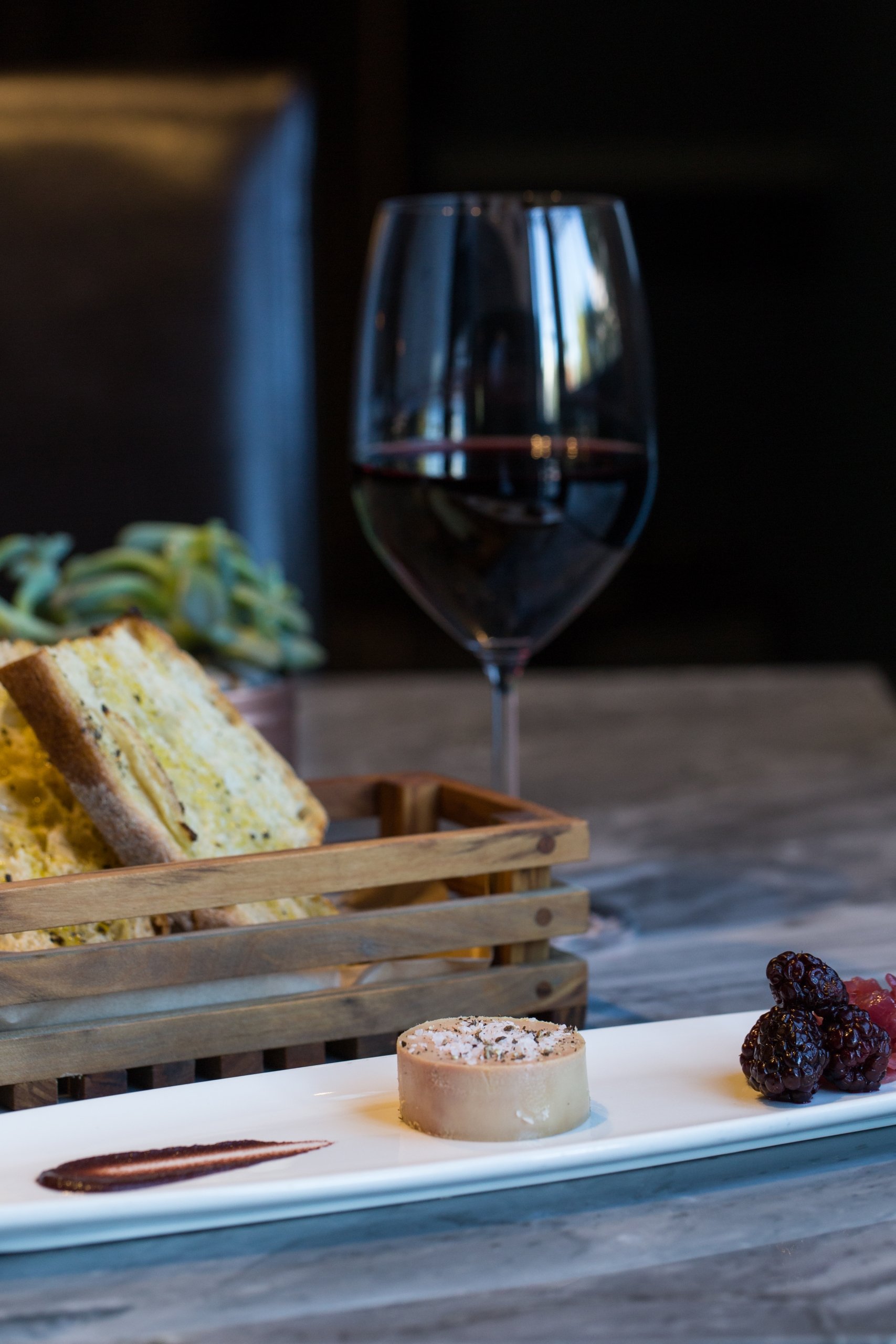 red wine in glass with bread and cheese plate