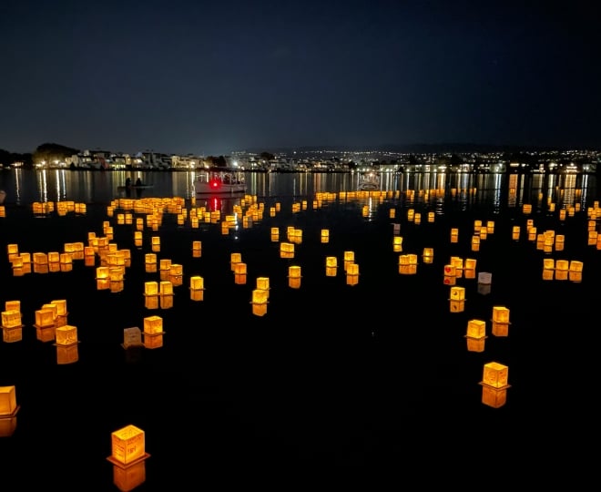 Lanterns floating in the water at night.