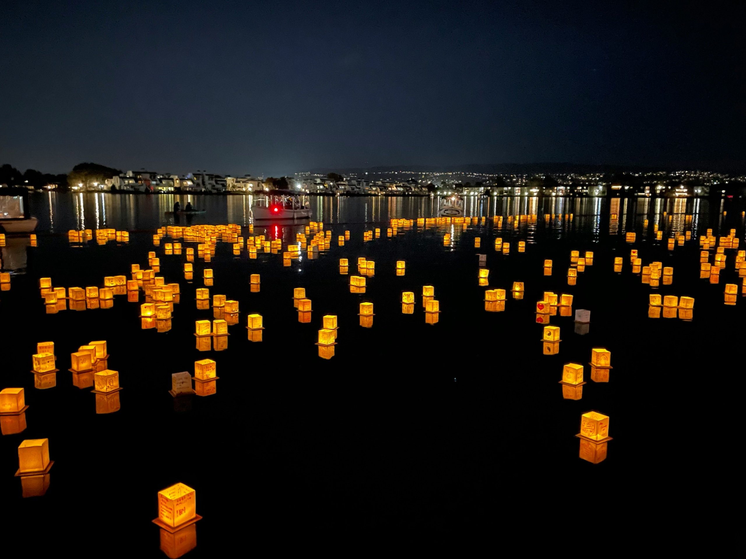 Lanterns floating in the water at night.